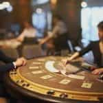 A blackjack dealer lays out her cards on a card table.