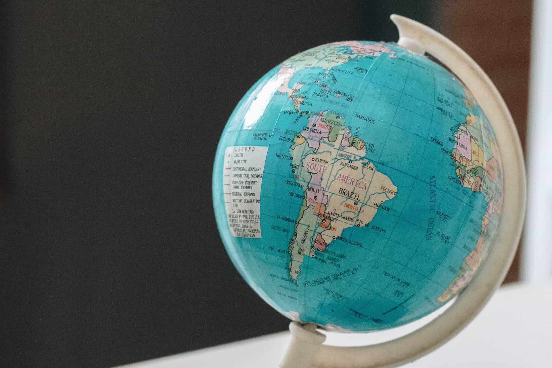 A plastic globe sits on a desk, with the area of South America in focus.